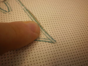 Once you’ve finished stitching all of your applique shapes and tying off the threads, turn your block over and start to remove the Stitch-N-Tear. Support the stitches with your fingers and gently tear away the Stitch-N-Tear – it has been perforated by the stitches so it doesn’t need cutting.