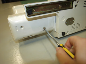 Lie the machine back down and reattach the cover plate.